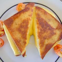 two grilled cheese sandwiches on a plate with tomatoes