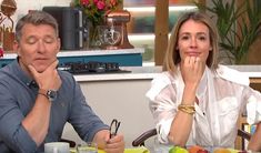 a man and woman sitting at a table with fruit on the plate in front of them