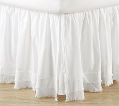 a white bed skirt with ruffled edges