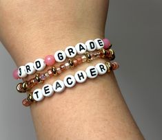 * This listing is for a set of three teacher stackable personalized beaded bracelets. this listing includes one teacher bracelet, one  accent bracelet, and one grade level or subject bracelet  Details: - Handmade to order - Standard adult bracelet length (6.75")  - Glass beads, metal beads, plastic seed beads - Secured with tied and burned knot *Please measure your wrist to ensure correct sizing. We are more than happy to accommodate custom sizing *Please double check spelling and bead selection Personalized Beaded Bracelets For Teacher Appreciation, Teacher Bracelet, Bracelets Diy, Orlando Fl, Metal Beads, Friendship Bracelet, Diy Bracelets, Bracelet Set, Beaded Bracelet