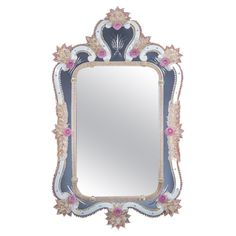 an ornate mirror with pink and white flowers on the border, against a white background