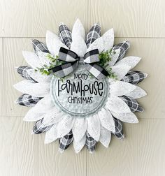 a christmas wreath with the words merry farmhousemas written in black and white on it