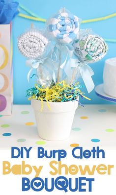 a baby shower bouquet in a white pot on a table with blue and yellow streamers