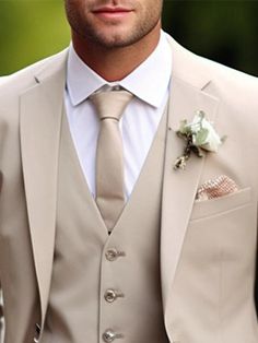 a man wearing a suit and tie with a boutonniere on his lapel