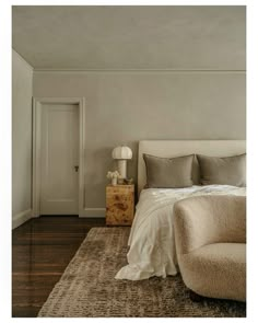 a bedroom with white walls and wood floors