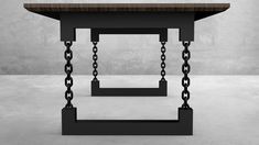 a black table with chains on it and a white wall in the backround