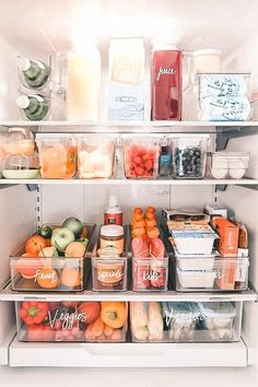 an open refrigerator filled with lots of different types of fruit and juice in plastic containers