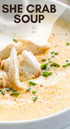 a white bowl filled with soup and garnished with scallops