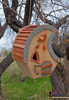 a wooden birdhouse hanging from a tree