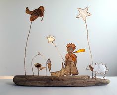 a wooden figurine is sitting on top of a piece of wood with stars