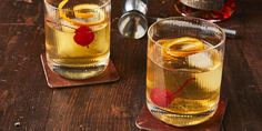 two glasses filled with liquid sitting on top of a wooden table