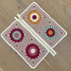 two crocheted placemats sitting on top of a wooden floor