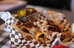 a basket filled with food sitting on top of a checkered tablecloth covered table