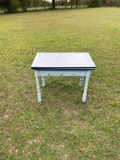 a small blue table sitting in the middle of a field