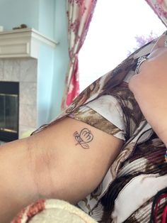 a person with a tattoo on their arm laying down in front of a fire place