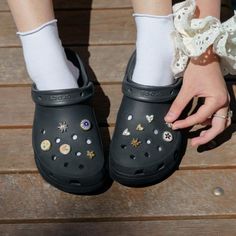 a close up of a person's feet wearing clogs and shoes with jewels on them