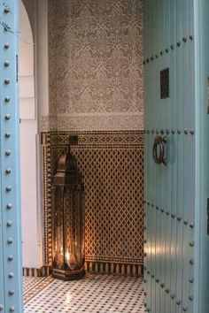 an ornately decorated hallway with a lantern in the center and tiled walls behind it