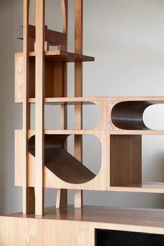 a wooden shelf with shelves on top of it and an object in the middle that is shaped like a spiral staircase