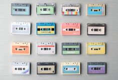 many different colored cassettes are arranged in rows on a gray surface with white trim