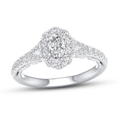 a diamond engagement ring with an oval center and pave set diamonds around the band