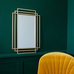 a green room with a yellow chair and a mirror hanging on the wall next to it