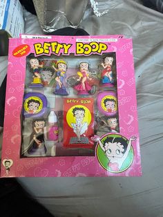 the box is open and has various toy figures in it, including betty boop