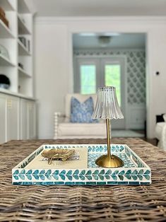 a tray with a lamp on top of it sitting on a table in a living room