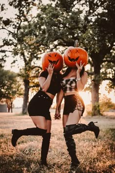 two women dressed up in costumes holding pumpkins