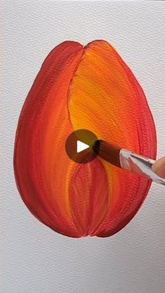 someone is painting an orange flower with a brush