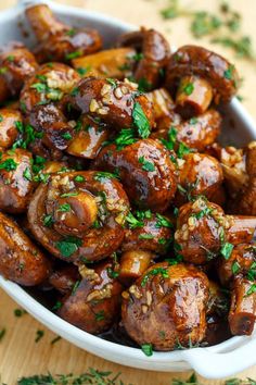 a white bowl filled with meat covered in parsley