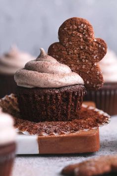 cupcakes with frosting and heart shaped cookies on the top are ready to be eaten