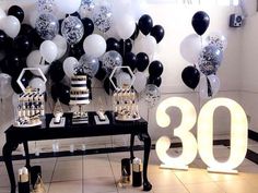 the table is set up with balloons and cake for an 80th birthday party or celebration