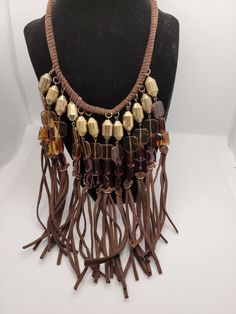 Vintage Brown Faux Suede Fringe Collar Statement 20-inch Necklace with 3-inch extender. This BoHo style necklace is suitable for any occasion and is light weight and comfortable to wear. Features brass colored metal and brown colored glass beads. This vintage treasure has been previously loved and worn and with any vintage item there might be slight imperfections, blemishes or inconsistencies. I would love to see you wearing your new necklace, please tag me on FB @Parididdles or on Instagram and if you're happy with your purchase please don't forget to write a review! Thank you for taking the time to visit my shop! Brown Costume Jewelry Necklace For Party, Brown Necklace With Adjustable Chain, Brown Metal Beaded Necklaces As Gifts, Brown Metal Beaded Necklace For Gift, Adjustable Brown Metal Jewelry, Brown Costume Jewelry Beaded Necklaces For Party, Brown Metal Necklace For Party, Adjustable Brown Beaded Necklaces, Adjustable Brown Metal Necklaces