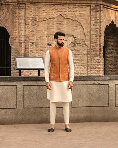 This item is made specially for you by hands with love  Item Contains:  Kruta  Vest and  Pants  Fabrics :   Luxury silk  Colours :  Cream kurta pyjama & Orange vest  Style and Designs :  Kurta has mandarin collar and long sleeves with a full button placket symmetric hem up to knee and multiple slits Vest coat has mandarin collar and five button placket with straight cut bottom design has two pocket with bone and it is hand embroidered with dabka golden dabka work all over embroidery motifs  Trousers come with a mid rise fit and four pockets with fly on the zip and also has a hook and a button on the belt Size :  Slim fit  Model height is 6 fit and wearing 40 size  Material and Care :  Polyester mix  Only dry clean  Note :  There might be slightly changes in colours as effect of light and p Mendhi Outfit, Engagement Suits, Coat And Pants, Mens Indian Wear, Mehndi Outfit, Wedding Kurta, Indian Groom Wear