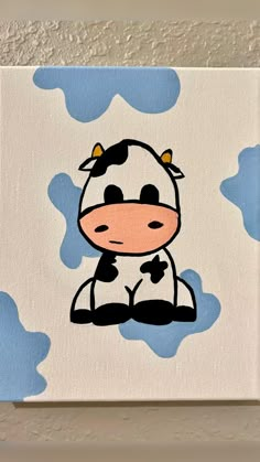 a painting of a cow sitting on top of a blue and white cloud covered wall