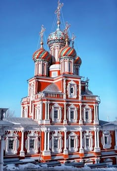 an orange and white building with many spires on it's sides in the snow