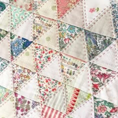 a close up view of a quilt with many different colors and designs on it's sides