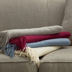 a pile of blankets sitting on top of a couch