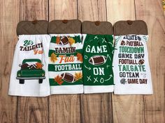 three green and white towels with footballs on them, hanging from the side of a wooden wall