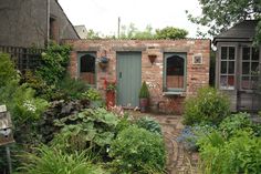 an old brick building surrounded by plants and trees