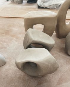 several clay sculptures sitting on top of a wooden table in a room with other items