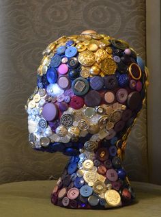 a head made out of buttons on top of a table