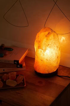 a lamp that is sitting on top of a table next to some books and other items