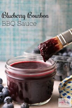 blueberry bourbon bbq sauce in a glass jar with a brush sticking out of it