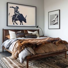 a bed room with a neatly made bed and two pictures on the wall above it