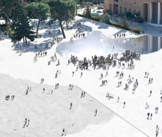 an aerial view of people walking and sitting on the sand in front of a building