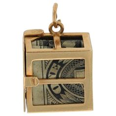 an open box with money in it on a white background and gold plated chain