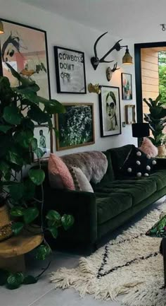 a living room filled with lots of green furniture and pictures on the wall above it