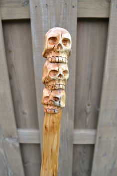 a wooden stick with carved skulls on it