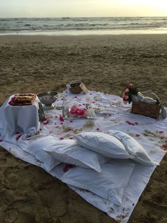 a picnic set up on the beach with food and drinks